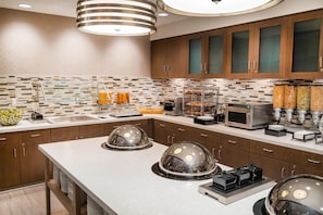 A modern kitchen with a central island, built-in appliances, and a variety of food dispensers. - Homewood Suites by Hilton Livermore, CA (Livermore)