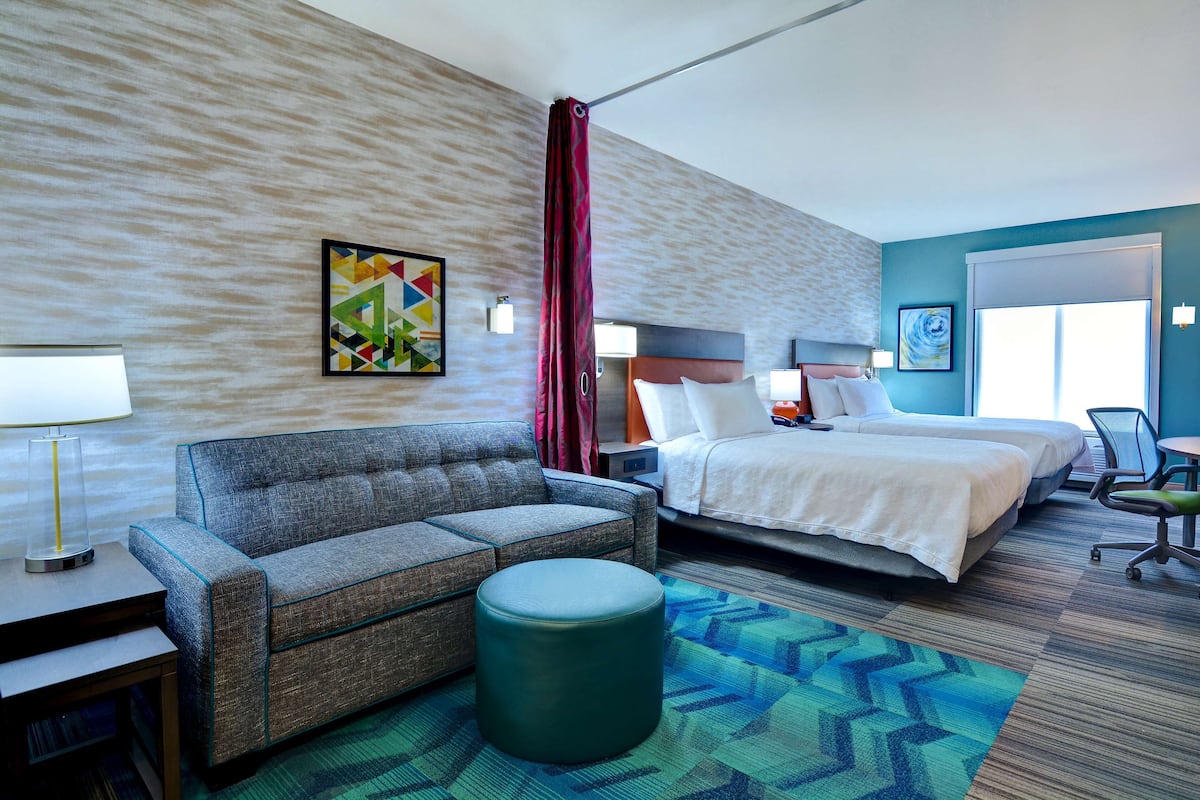 Une chambre d’hôtel avec un canapé, un lit, un bureau et une chaise.
