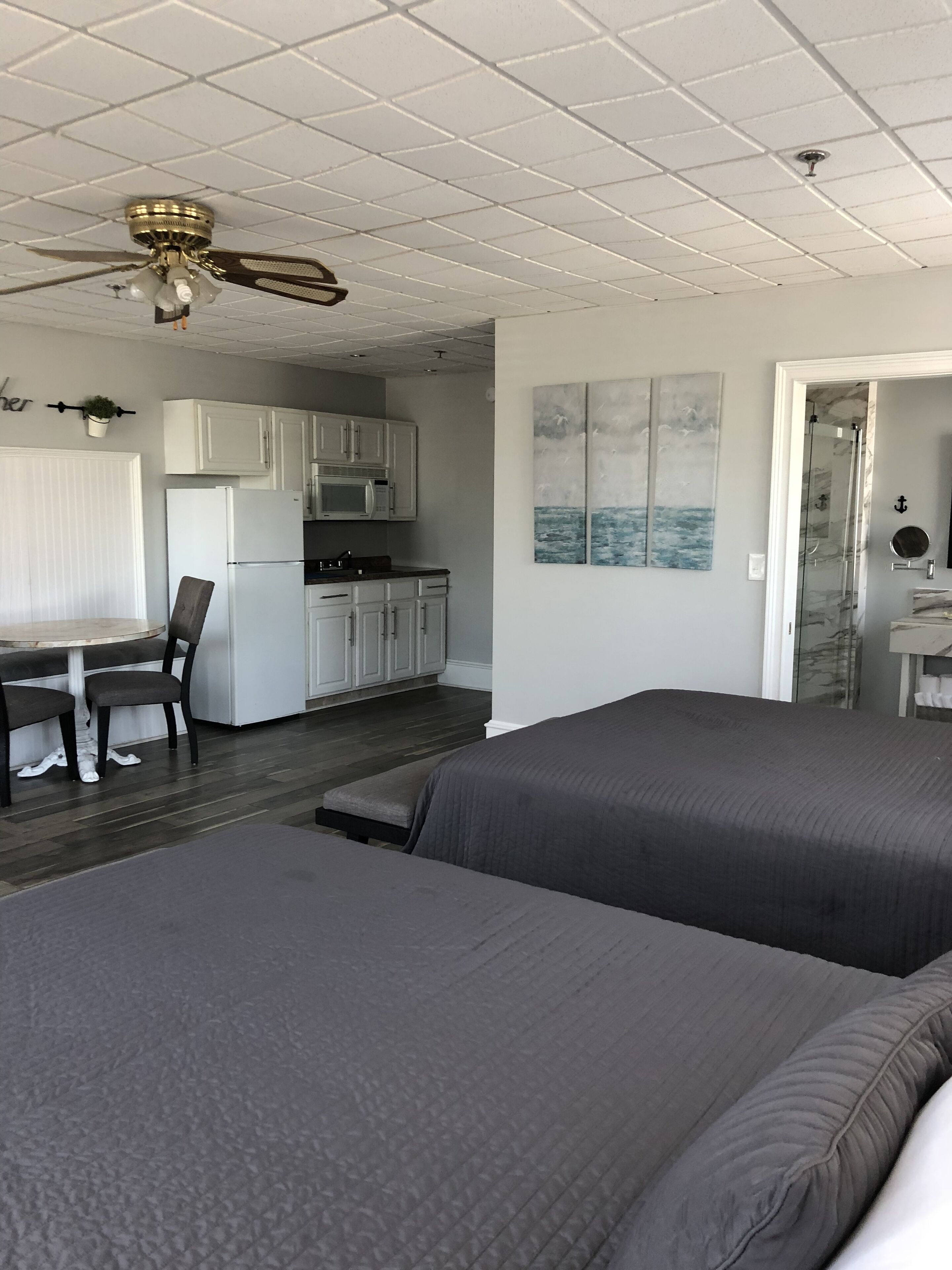 Un dormitorio con dos camas, kitchenette, comedor y baño.