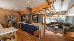 Eine moderne Küche mit Holzschränken, einem eingebauten Herd und einem Edelstahlkühlschrank.