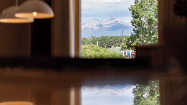 Ein modernes Interieur mit einem großen Fenster, das Blick auf Berge und Grünflächen bietet.
