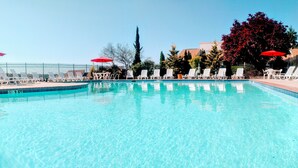 Ein klares Schwimmbecken mit Liegestühlen und Sonnenschirmen.