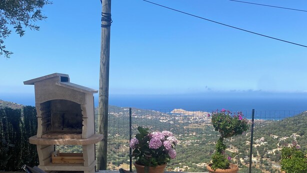 A patio with two lounge chairs, a stone fireplace, and potted plants. - Ground floor apartment, T2 type, sea view. (Santa-Reparata-Di-Balagna)