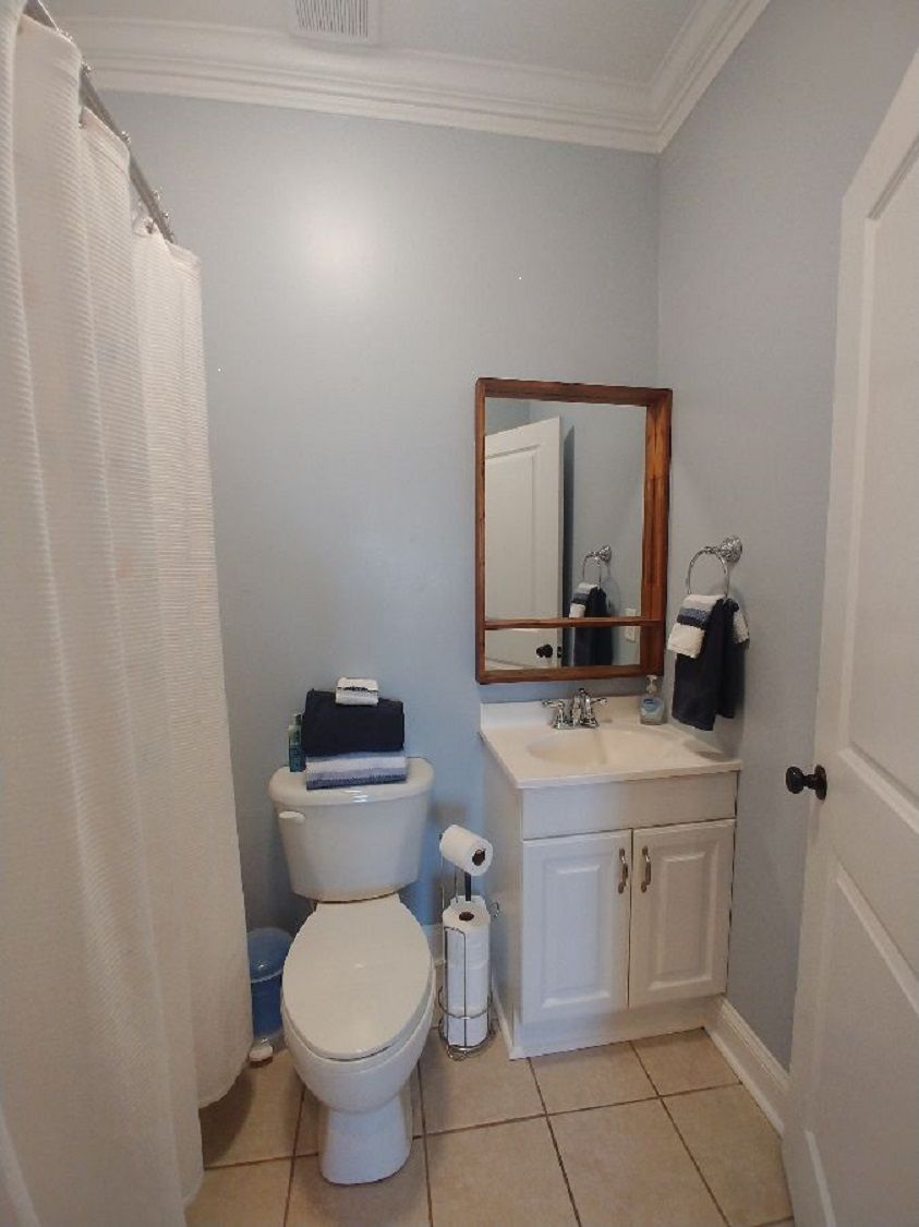 A small bathroom with a toilet, sink, and mirror.