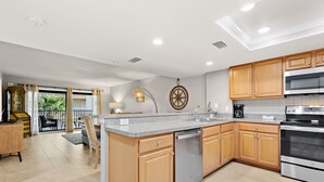 A modern kitchen with wooden cabinets, stainless steel appliances, and a large island.