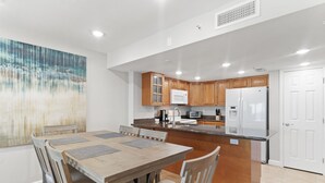 Una cocina moderna con armarios de madera, encimera de granito y una isla central con asientos.