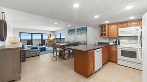 Una cocina moderna con una isla central, armarios de madera y electrodomésticos blancos.
