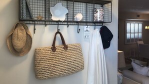 Una estantenca penjada amb objectes decoratius i una bossa teixida.