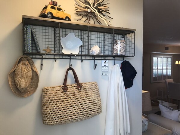 A wall-mounted shelf with decorative items and a woven bag.