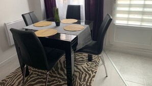 A dining area with a glass table, black chairs, and a zebra-patterned rug. - Cosy accommodation near Paris and Disneyland (Villiers-sur-Marne)