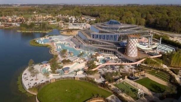 An aerial view of a resort with a large pool, a water slide, and a unique building structure. - Cosy accommodation near Paris and Disneyland (Villiers-sur-Marne)