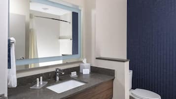 A modern bathroom with a marble sink, a mirror, a towel, and a toilet.