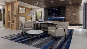 A modern living room with a sofa set, a coffee table, and a TV mounted on the wall. - Fairfield Inn & Suites by Marriott Monahans (Monahans)