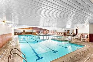 Una piscina techada, sillones reclinables de piscina