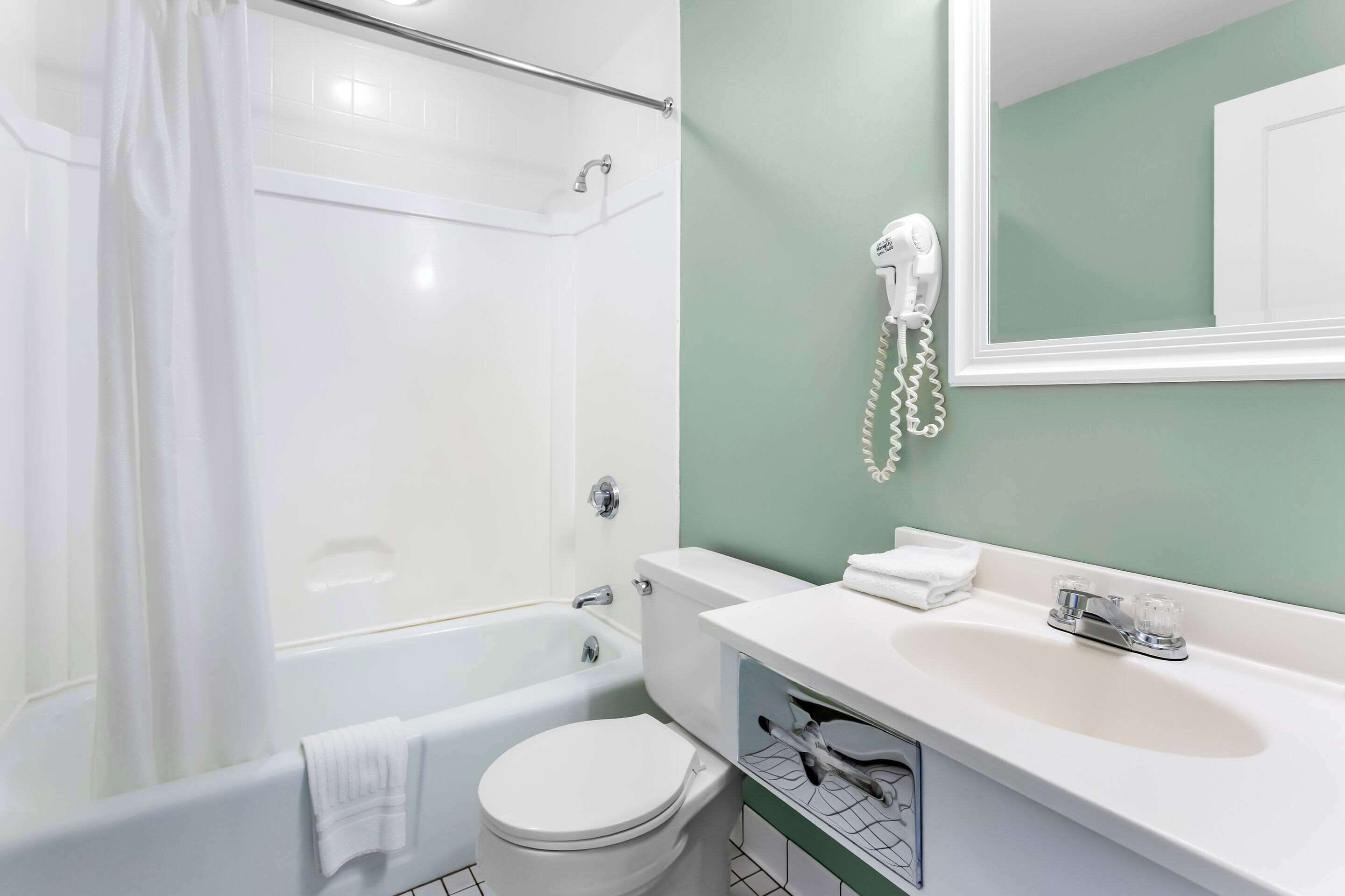Une salle de bain avec une baignoire, des toilettes et un lavabo avec un miroir au-dessus.