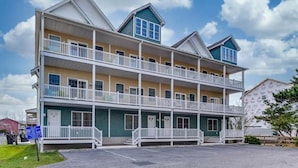 A multi-story motel with a central courtyard, balconies, and a parking lot.