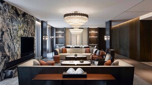 A modern living room with a large chandelier, a sofa set, and a flat-screen TV. - Wuhan Marriott Hotel Optics Valley (Wuhan)
