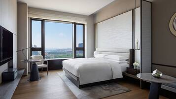 Habitación de hotel moderna con una cama grande, un escritorio, una silla y un televisor.