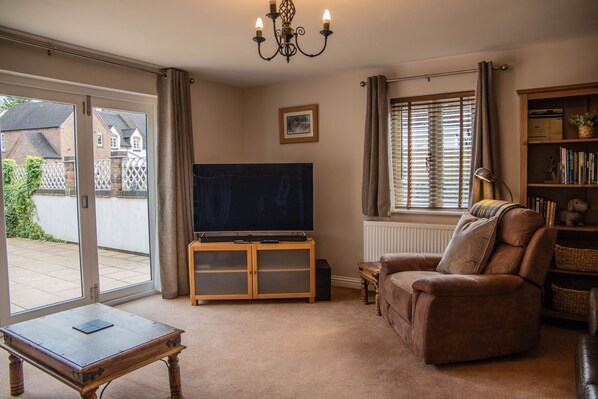 A living room with a television, sofa, and a table. - Dale Cottage (Telford)