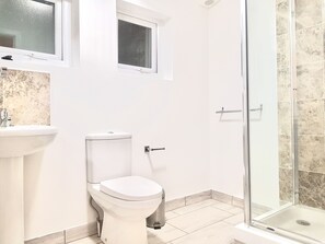 Ein Badezimmer mit Toilette, Waschbecken und Dusche.
