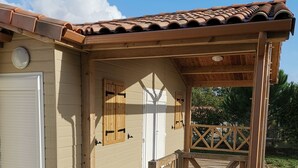 Un rivestimento in legno che conduce a un edificio con tetto in tegole e veranda coperta.