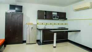 A compact kitchen with a refrigerator, microwave, and stove.