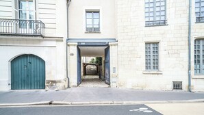 A street view with a building entrance, a green door, and a pedestrian crossing. - Architect-designed house in Tours center garden terrace, A/C, parking (Tours)
