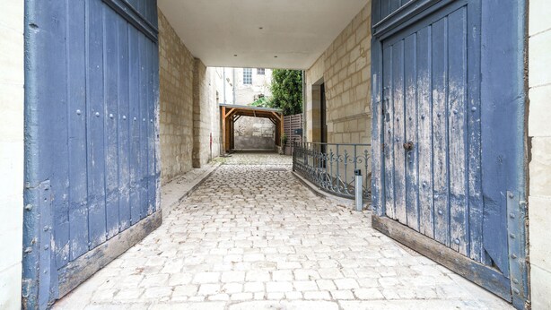 A cobblestone pathway leading to a wooden archway between two blue doors. - Architect-designed house in Tours center garden terrace, A/C, parking (Tours)