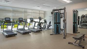 A gym with treadmills, elliptical machines, and weightlifting equipment.