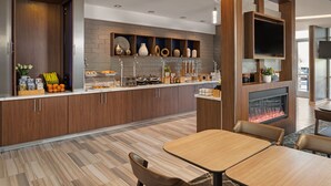 Una cocina moderna con estufa integrada, armarios de madera y una variedad de utensilios de cocina exhibidos en estantes.