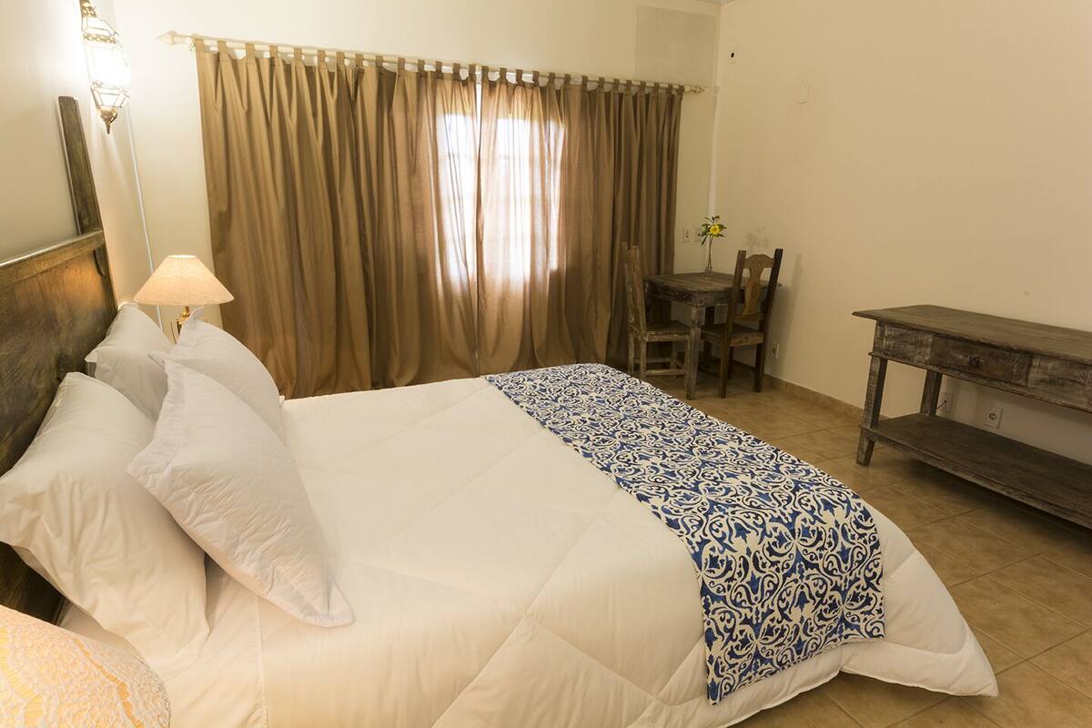 Ein Hotelzimmer mit Bett, Schreibtisch, Stuhl und Lampe.