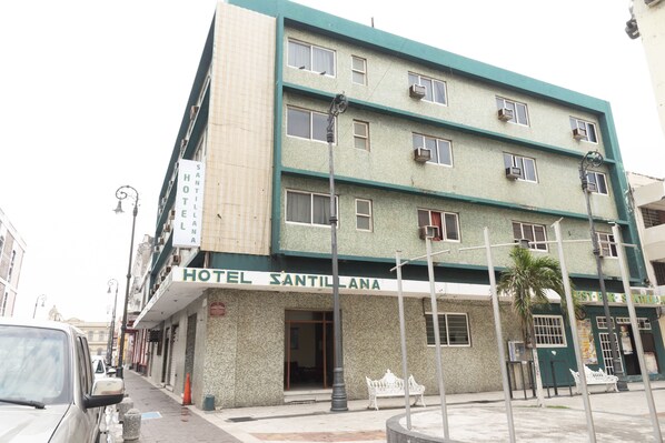 A multi-story building with a sign reading "HOTEL SANTILLANA".