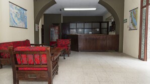 Una zona de recepción con muebles de madera y un mapa en la pared.