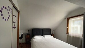 Una camera da letto con un letto, una scrivania e una sedia.