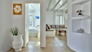 A spacious living area with a large window, a sofa, a coffee table, and a decorative fish on a shelf. - Villa Leo, 3km From the Paroikia With a Nice View of the Paroikia and Port (Paros)