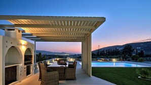 An outdoor patio with a grill, seating, and a pool. - Villa Leo, 3km From the Paroikia With a Nice View of the Paroikia and Port (Paros)