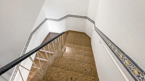 A staircase with a black handrail, white walls, and a patterned border. - Suite Natura @ Casa del Lago (Puerto de la Cruz)