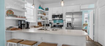 Spacious beach house steps to the powdery white sand and emerald water.