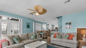 A spacious living room with two sofas, a coffee table, and a ceiling fan. - Palm Place, Spacious beach house steps to the powdery sand and emerald water. (Destin)