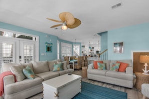 A spacious living room with two sofas, a coffee table, and a ceiling fan.