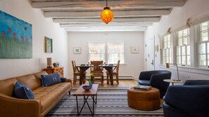 Relax in this spacious living area with a dining table, comfortable sofa, and armchair.