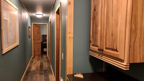 Un couloir avec des armoires en bois, un comptoir noir et un plancher en bois.