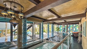 A pool area with a glass railing, a staircase, and a view of the outdoors. - Beachfront Home on Gulf of Mexico w/ Indoor Pool (Englewood)
