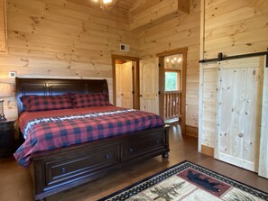 A wooden cabin bedroom with a bed, nightstands, a dresser, and a wardrobe. - Selah View  Stunning 5 BR mountain lodge - Incredible views, 3mi to Pigeon Forge (Sevierville)