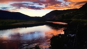Un paysage paisible, avec une rivière qui reflète le ciel, entouré de collines.