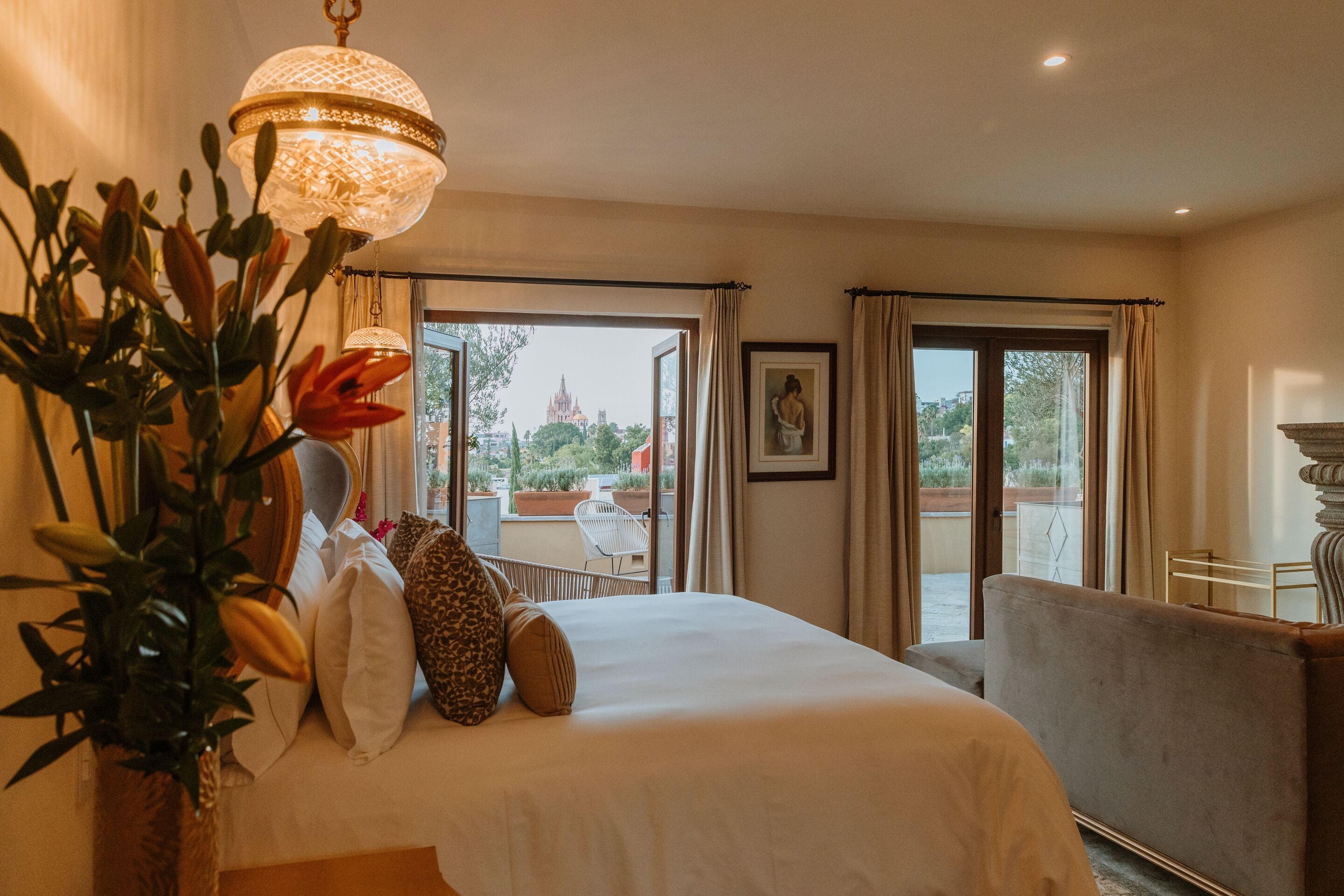 A hotel room with a bed, a large window, and a balcony.
