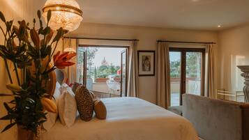 A hotel room with a bed, a large window, and a balcony.