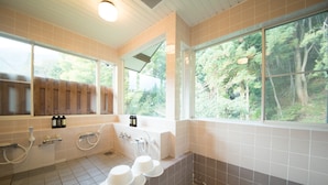 A bathroom with a bathtub, multiple sinks, and large windows offering a view of trees. - Guest House Lamp Bungo Ohno - Hostel (Bungoono)