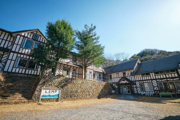 A traditional half-timbered building with a stone wall and a sign reading "LAMP".