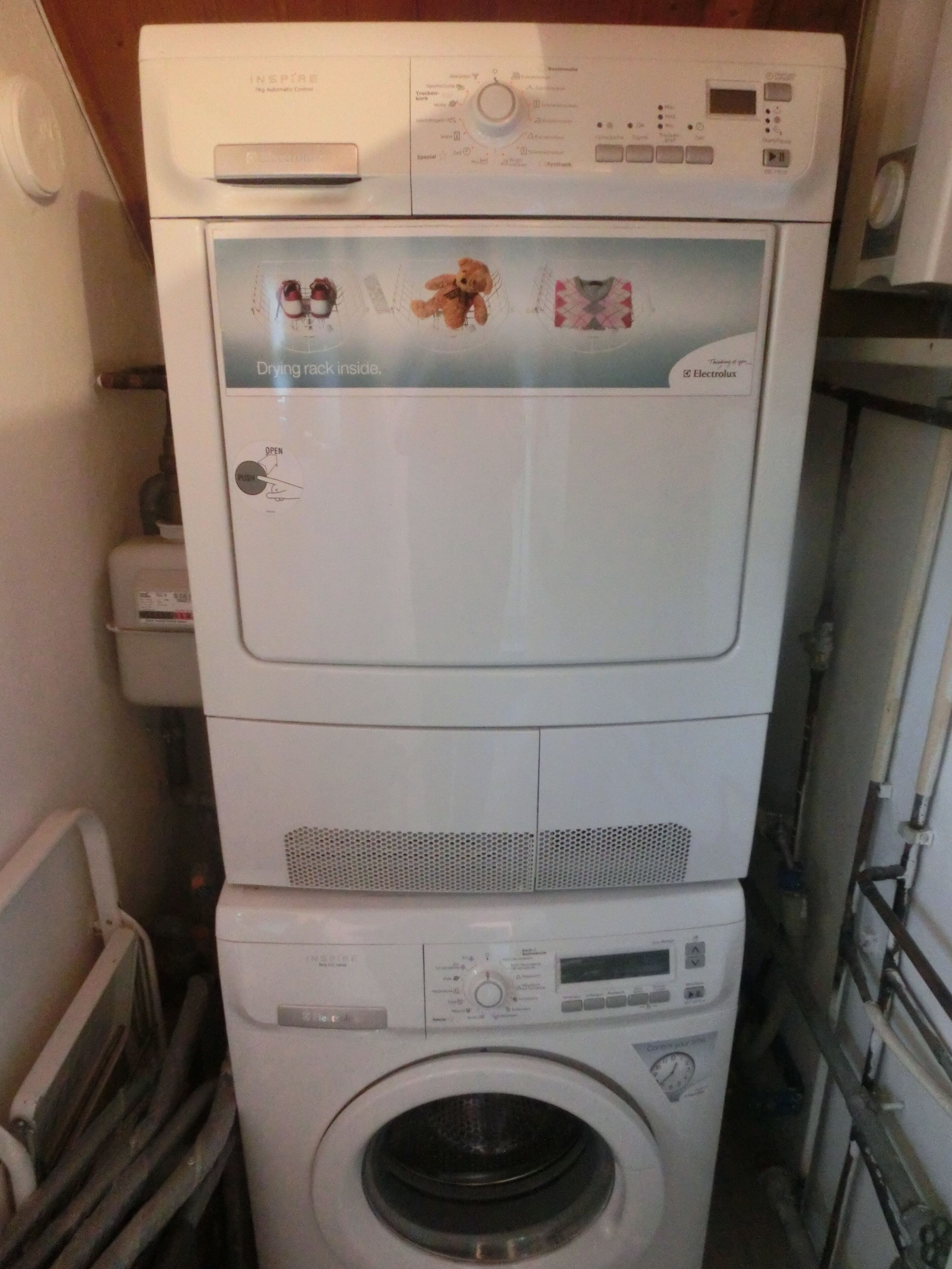 Una lavadora y secadora apiladas en un cuarto de lavado.